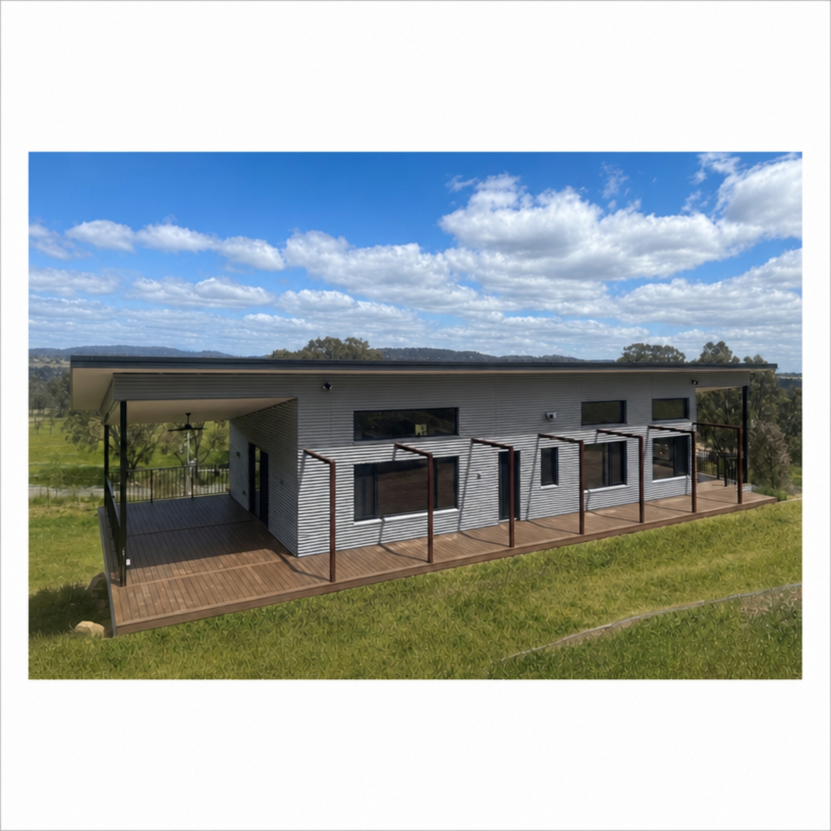 Viva Panel home with corrugated metal cladding, skillion roof, wraparound timber deck and rural outlook