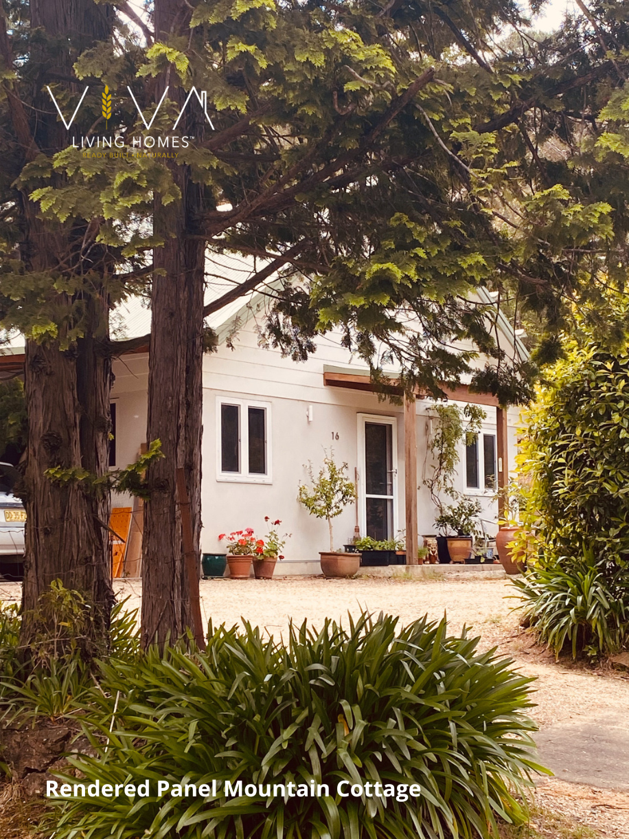 Rendered Viva Panel mountain cottage with white walls, metal roof and established garden framed by tall trees