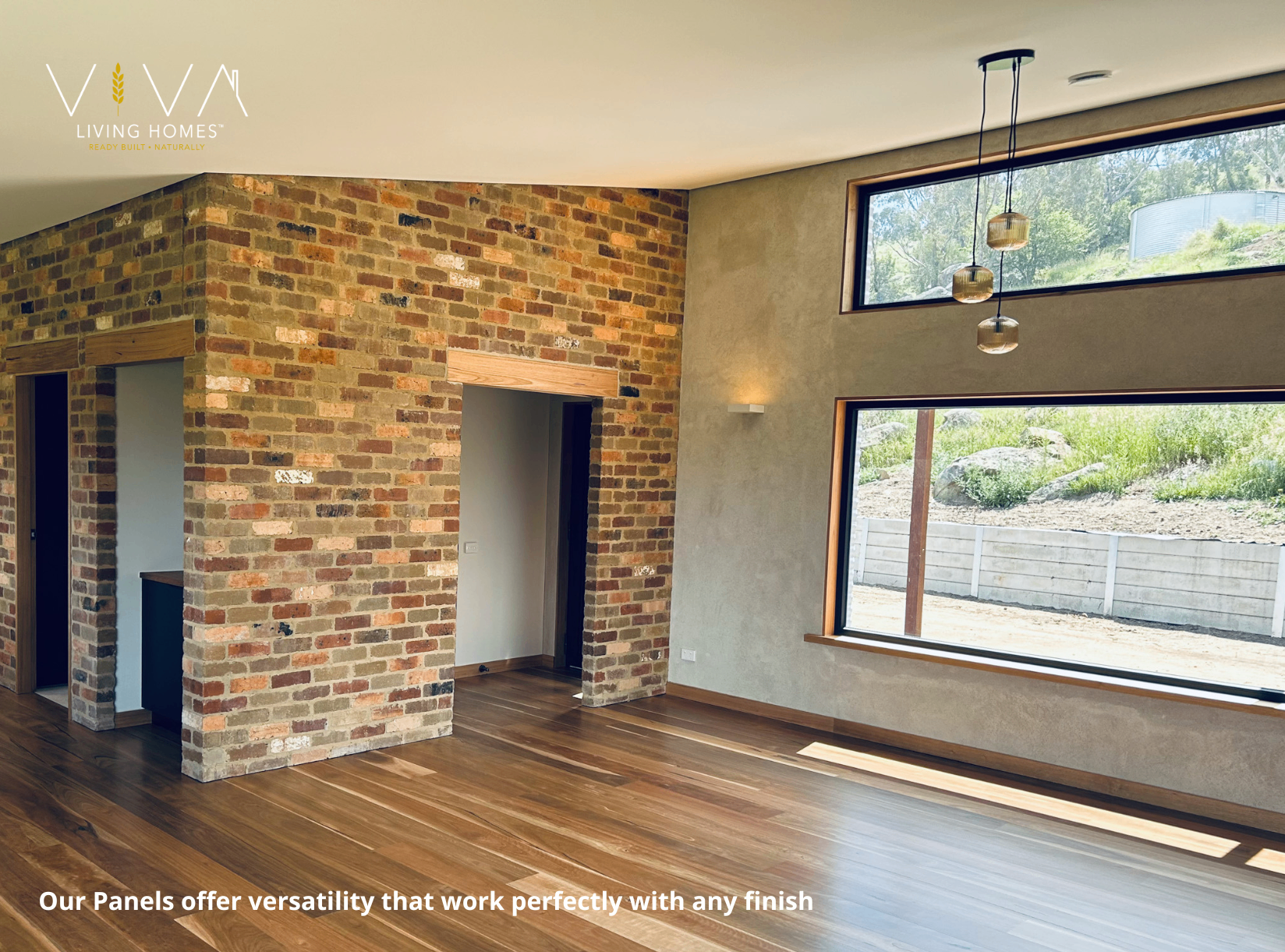 Open-plan Viva Panel interior with recycled brick feature wall, rendered straw walls, timber floors and large picture windows