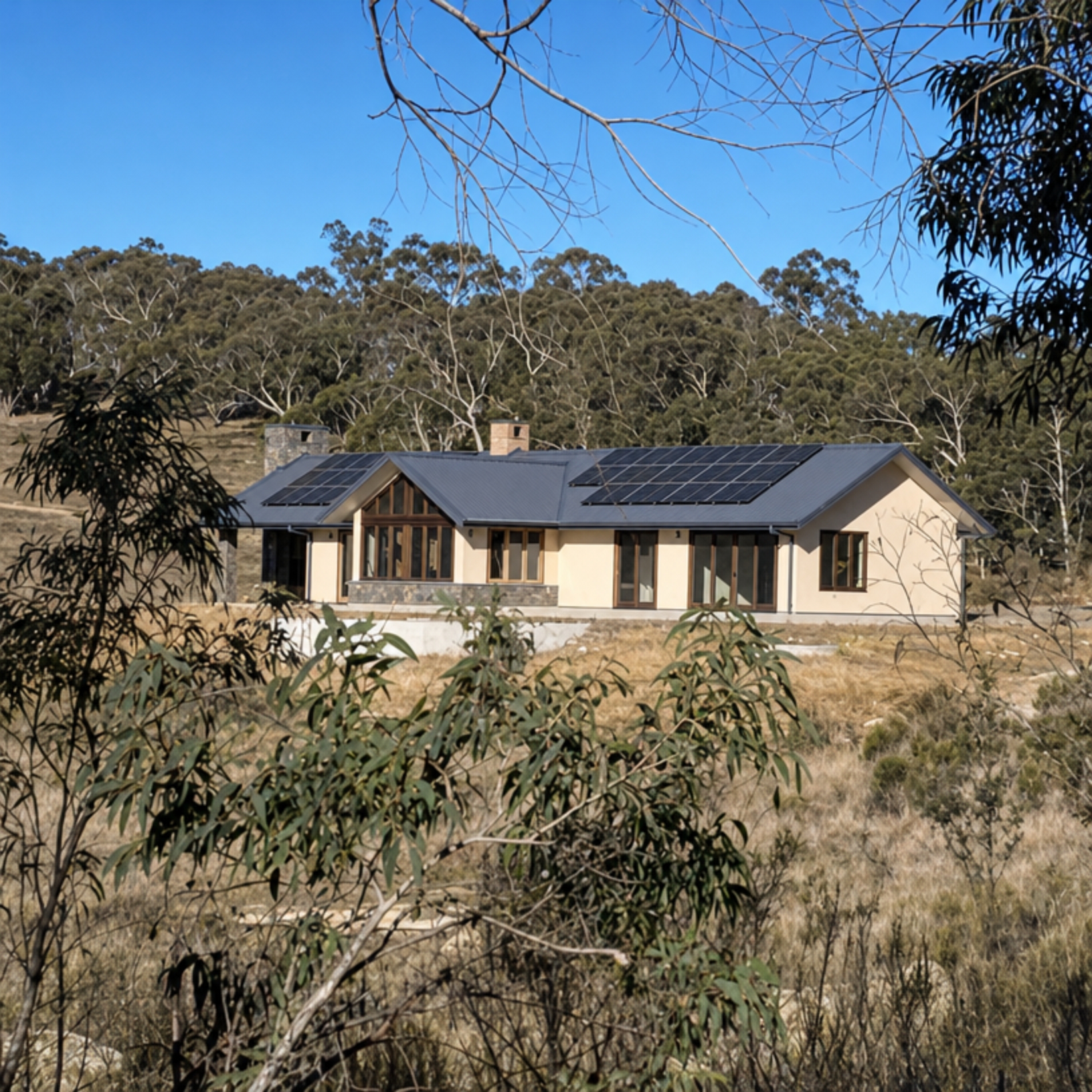 Viva Panel rural home with gabled metal roof, solar panels, rendered straw walls and timber-framed windows set in bushland